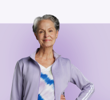 Woman in grey zip-up hoodie with purple background